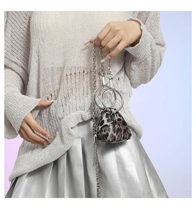 Dettaglio mini borsa leopardata con catena argento indossata da una modella