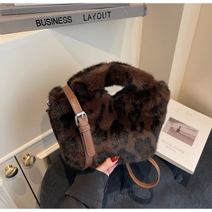 Detail of vintage leopard print faux fur handbag with brown leather strap and silver buckle