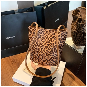 Detail of leopard print bucket bag featuring dark brown handles and soft matte texture