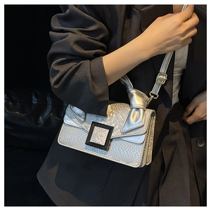 Detail of silver faux snake skin shoulder bag featuring a large black matte square buckle