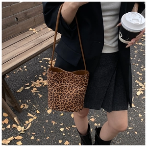 Outdoor street style shot of a vintage leopard print bucket bag with brown straps
