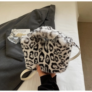 Detail showing plush black and white leopard print faux fur texture and silver metal buckle