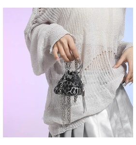 Dettaglio mini borsa leopardata con manico ad anello in metallo argento e frange di catene