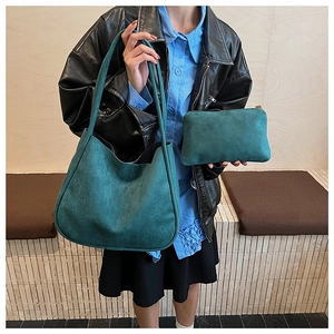 Detail view of dark green faux suede tote bag and matching envelope pouch set