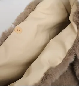 Detail view of brown plush faux fur handbag featuring dual golden magnetic snap closures