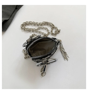 Dettaglio mini borsa pitonata con grande anello d'argento e nappa di strass