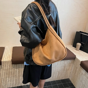 Detail view of large brown faux suede shoulder bag showing soft texture in lifestyle setting