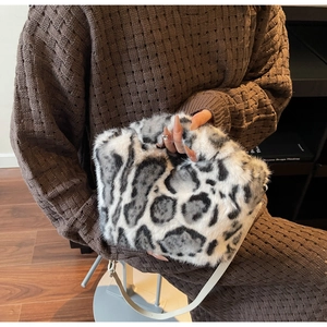 Detail of soft leopard print faux fur handbag with sleek white leather shoulder strap