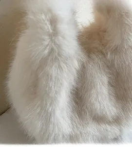 Gros plan sur la texture en fausse fourrure moelleuse d'un sac à main en peluche beige