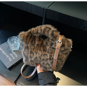 Detail of leopard print faux fur handbag with adjustable brown leather shoulder strap