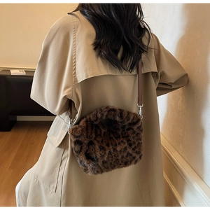 Detail of leopard print plush crossbody bag styled with a stylish khaki trench coat