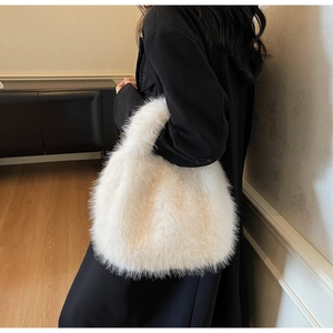 Close-up of white faux fox fur handbag with plush texture and elegant round handle