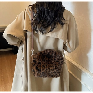 Detail view of leopard print plush handbag with silver buckle on khaki trench coat outfit