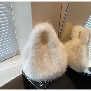 Close-up of soft white faux fur handbag with plush texture and minimalist design
