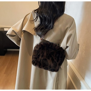 Detail of leopard print plush crossbody bag styled with a khaki trench coat for autumn