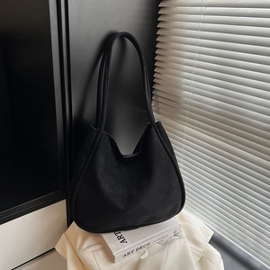 Detail of minimalist black matte suede tote bag featuring slim straps and half-moon shape