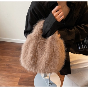 Détail du sac à main en fausse fourrure marron porté par un mannequin dans un décor épuré