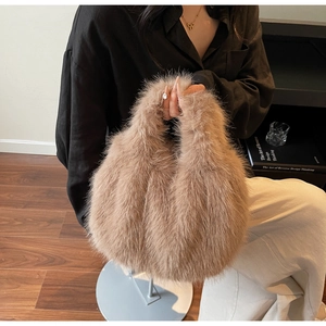 Detail of fluffy brown faux fox fur handbag with top handle in a lifestyle setting