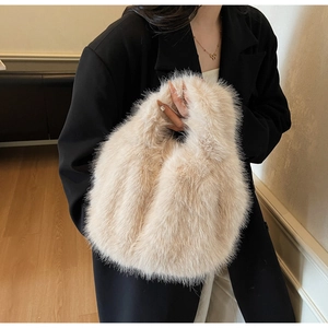 Close-up of a fluffy beige faux fur handbag paired with a black blazer for autumn