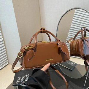Brown vintage baguette handbag with gold lettering and adjustable crossbody strap