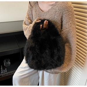 Close-up detail of luxury black faux fur handbag with soft fluffy texture and glossy finish