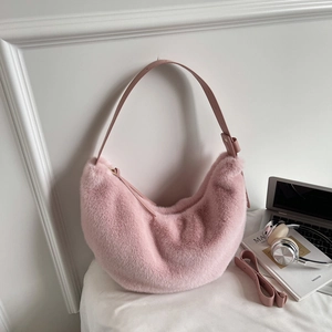 Sac hobo rose en peluche avec bandoulière réglable sur un fond esthétique épuré