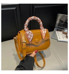 Mustard yellow square handbag with scarf-wrapped handle and adjustable strap