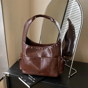 Retro dark brown rivet tote bag with vintage texture for elegant 2025 winter commute
