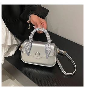 Silver metallic handbag with silk scarf wrapped handle and round buckle detail