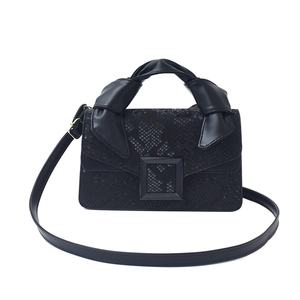 Fashionable black faux snakeskin handbag with knot handle and adjustable crossbody strap