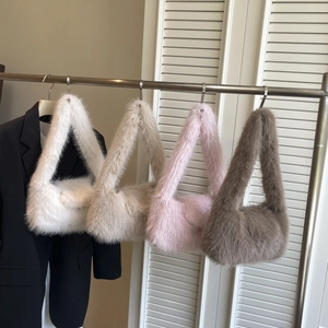 Faux fur shoulder bags in white, beige, pink and grey displayed on a rack