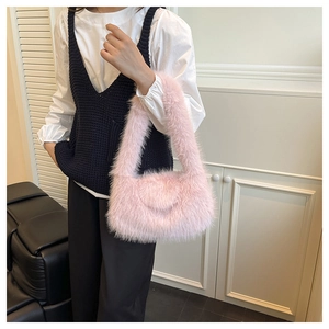 Detail view of a pink plush faux fur handbag with a soft texture and crossbody strap