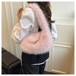 Close-up of pink faux fur shoulder bag worn by model, showing fluffy texture and style