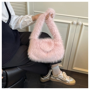 Detail of soft pink faux fur handbag with fluffy texture and rounded crescent shape
