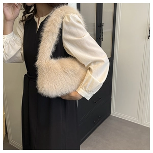 Detail of soft beige faux fur shoulder bag texture showing the fluffy plush material