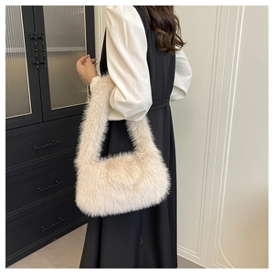 Shoulder view of a plush beige faux fur tote bag with a soft minimalist design