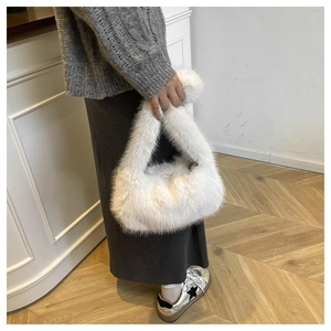 Detail of soft white faux fur tote bag showing plush texture and triangular silhouette