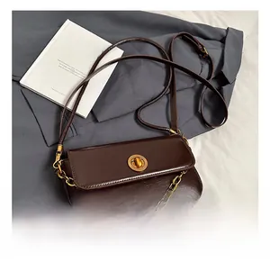 Macro view of dark brown glossy PU leather crossbody bag with golden chain and lock