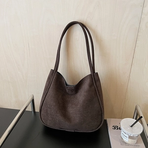 Minimalist dark brown suede tote bag with double straps on a modern minimalist desk