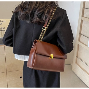 Vista posteriore di una modella che indossa la borsa a tracolla in pelle marrone scuro