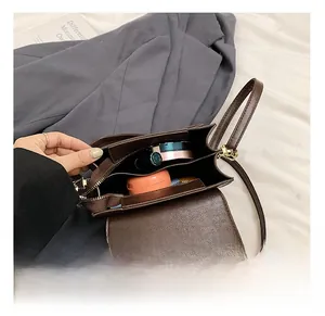 Interior view of small square bag showing main compartment with a metal zipper pocket