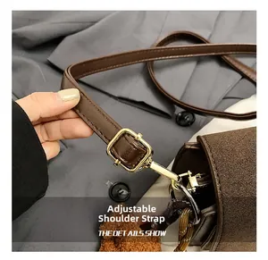 Detail of adjustable strap on brown vintage square bag with golden buckle