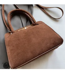 Detail of vintage brown matte tote bag featuring gold buckle and soft leather texture