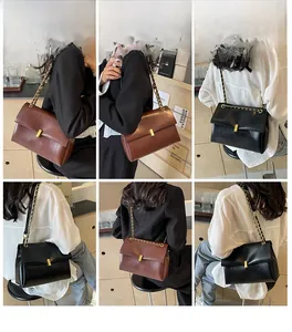 Detail view of large chain tote bag with gold buckle on shoulder and crossbody wear