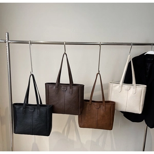 Serie di grandi borse tote in nero, caffè, marrone e crema con trama in ecopelle sintetica