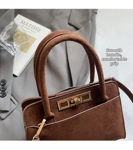 Detailed close-up of dark brown suede handbag with a gold twist lock and smooth round handles
