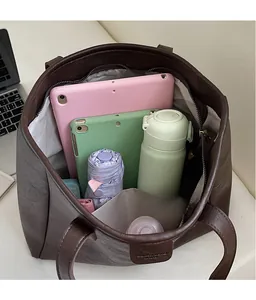 Interno spazioso della borsa tote marrone scuro che mostra la capacità per tablet e altro