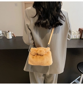 Detail of plush crossbody bag in caramel faux fur with cute pompom decorations