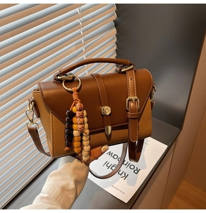 Détail du sac à main rétro en toile et cuir avec un pendentif décoratif en bois