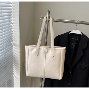 Dettaglio della borsa tote in ecopelle bianco crema con trama vintage e stampa a rilievo
